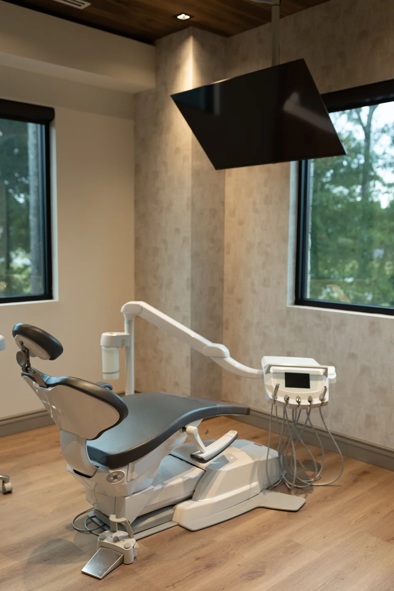Dental treatment room with large windows overlooking trees